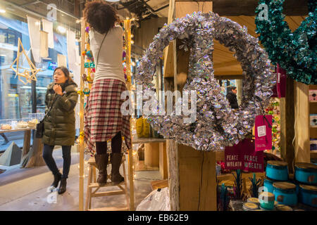 Ein Arbeitnehmer stellt ein Weihnachts-Display in einem Urban Outfitters Store am Herald Square in New York Stockfoto