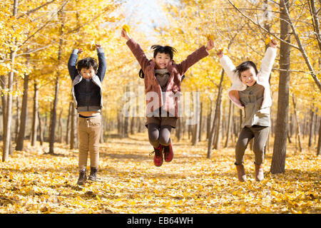 Drei Kinder spielen im herbstlichen Wälder Stockfoto