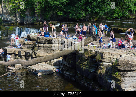 Massen von Jugendlichen spielen im Wasser, im Sommer auf dem Fluß Swale, Richmond, North Yorkshire, England Stockfoto