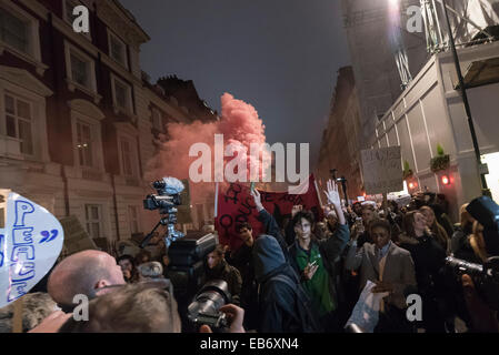 Zentral-London, UK. 26. November 2014. Demonstranten nehmen zu den Straßen von London nach der Demonstration vor der US-Botschaft, London, gegen die Entscheidung von einer Jury nicht Polizist Darren Wilson schießen tot Michael Brown, eine unbewaffnete 18-Year-Old, auf einer Seite Wohnstraße in Ferguson am 9. August in Rechnung zu stellen. Demonstranten skandierten "Hands UP nicht schießen" und "Wer ist unsere Straßen Straßen". Stockfoto