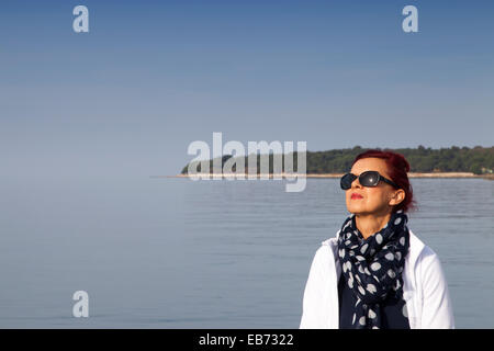 Hübsche Frau verfangen der Sonne Stockfoto