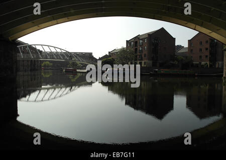 Sonniger Blick durch South Kreuzung Viadukt, Krämerbrücke, alte Lager reflektierenden Castlefield Junction, Manchester. UK Stockfoto