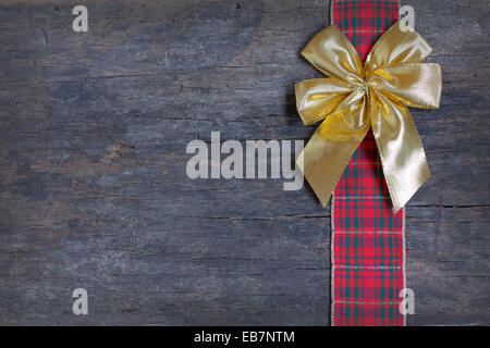 Weihnachten Ribbon und goldenen Geschenk Bogen auf alten hölzernen Hintergrund isoliert Stockfoto