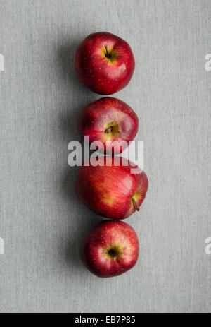Reife rote Äpfel hintereinander über grauen Tuch über Ansicht Stockfoto