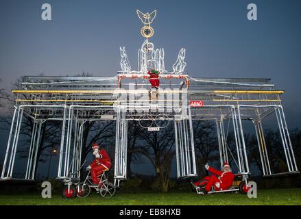 Storkow, Deutschland. 27. November 2014. Fahrrad Designer Dieter "Didi" Senft (R) Und seinem Enkel Tom Eberling präsentieren das beleuchtete mobile Brandenburger Tor, die ca. 7 Meter hoch in Storkow, Deutschland, 27. November 2014. Accoring, Senft er etwa 6000 LED verbaut leuchtet daher festliche scheint die Konstruktion. Seit Jahren arbeitet auf ungewöhnliche Fahrräder Senft und gewann zahlreiche Weltrekorde. Foto: Patrick Pleul/Dpa/Alamy Live News Stockfoto