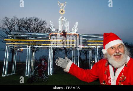 Storkow, Deutschland. 27. November 2014. Fahrrad Designer Dieter "Didi" Senft (R) Und seinem Enkel Tom Eberling präsentieren das beleuchtete mobile Brandenburger Tor, die ca. 7 Meter hoch in Storkow, Deutschland, 27. November 2014. Accoring, Senft er etwa 6000 LED verbaut leuchtet daher festliche scheint die Konstruktion. Seit Jahren arbeitet auf ungewöhnliche Fahrräder Senft und gewann zahlreiche Weltrekorde. Foto: Patrick Pleul/Dpa/Alamy Live News Stockfoto