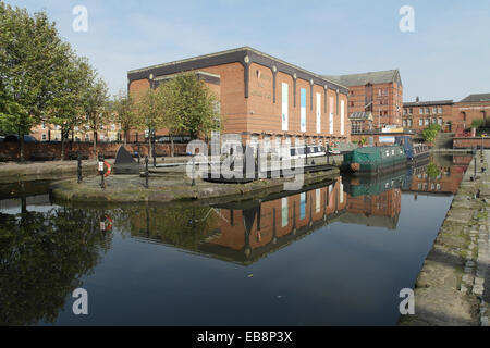 Blauer Himmel Reflexionen Blick auf Y-Club Gesundheitszentrum und Castlefield Hotel, Boote vertäut Wharf, Castlefield Canal Basin, Manchester Stockfoto