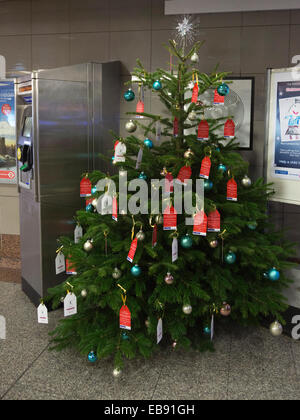 London, UK. 27. November 2014.  Weihnachtsbaum am Angel Tube Station. Das Islington Christmas Tree-Projekt des Kommissars der Metropolitian Polizei soll Weihnachten bieten stellt für benachteiligte Kinder in Obhut in Islington. Interessierte beitragen können per e-Mail islingtonxmastreeproject@met.pnn.police.uk und sie werden ein Kind um ein Geschenk zu kaufen. Bildnachweis: Nick Savage/Alamy Live-Nachrichten Stockfoto