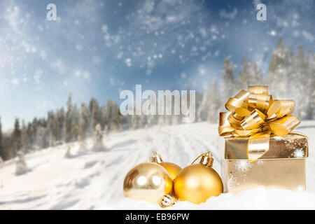 Weihnachtsschmuck und Geschenk boxin Front des Schnees kauerte Kiefern Stockfoto