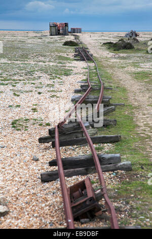 Gebrochene Gleise der stillgelegten Schmalspurbahn und einem verlassenen Schuppen in Dungeness, England Stockfoto