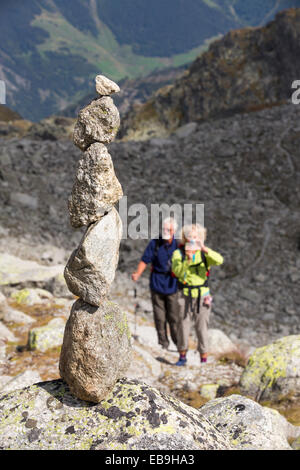 Wanderer machen die Tour du Mont Blanc aufsteigen in Richtung Cabanne D'Orny über dem Val Ferret in den Schweizer Alpen, mit einem Stein heruntergespült Stockfoto