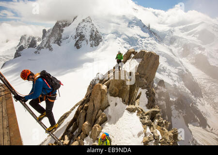 Mont Blanc von der Aiguille Du Midi über Chamonix, Frankreich mit Bergsteiger auf der Cosmiques Arete, Klettern die Leiter an die Cable Car Station zugreifen. Stockfoto