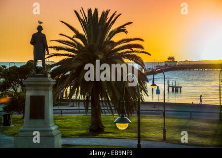 Blick auf den Sonnenuntergang über der Bucht. Silhouette des Captain Cook-Statue steht hoch, Blick auf das Meer in St Kilda, Melbourne Australien Stockfoto