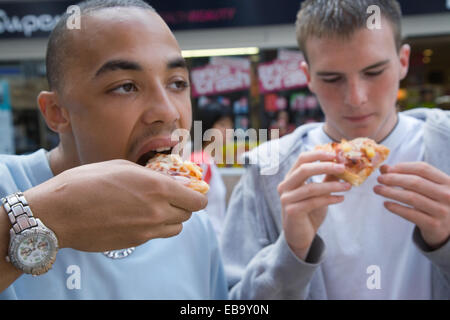 Zwei Teenager Jungs Naschen auf Pizza, Stockfoto