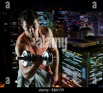 junger Mann mit Hantel Bizeps biegen Stockfoto
