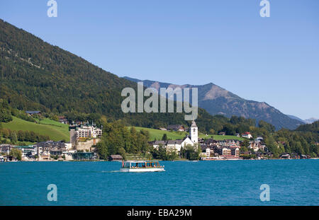 Regelmäßiger Service Boot am Wolfgangsee See mit der Wallfahrtskirche auf der Rückseite, St. Wolfgang, Salzkammergut, Oberösterreich Stockfoto