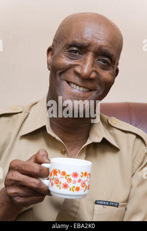 Älterer Mann sitzt zu Hause genießen Sie eine Tasse Kaffee, Stockfoto