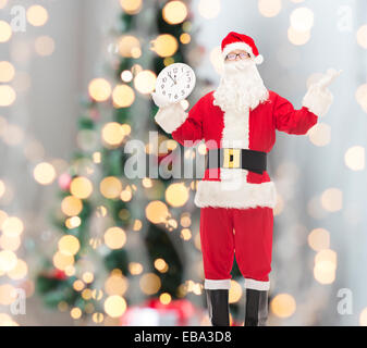 Mann im Kostüm des Weihnachtsmannes mit Uhr Stockfoto