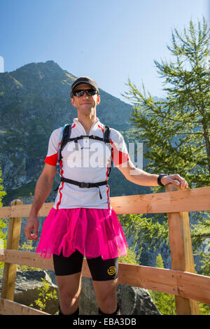 Ein Trailläufer in den französischen Alpen auf seinem Junggesellenabschied Urlaub trägt einen rosafarbenen Rock. Stockfoto