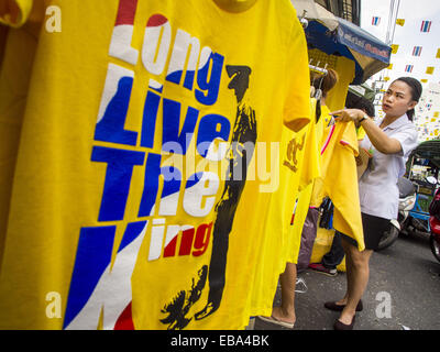 Bangkok, Bangkok, Thailand. 28. November 2014. Eine Frau in Bangkok befasst sich mit t-Shirts, die "Long Live the King'' vor dem Geburtstag des Königs in Thailand zu sagen. Bhumibol Adulyadej, der König von Thailand, geboren am 5. Dezember 1927, in Cambridge, Massachusetts. Die Familie war in den Vereinigten Staaten, weil sein Vater, Prinz Mahidol, Public Health an der Harvard University studierte. Hat der seit 1946 regiert und herrscht weltweit derzeit längste Umhüllung Monarch und der längste Umhüllung Monarch in der thailändischen Geschichte. Bhumibol, der in einem schlechten Gesundheitszustand ist, wird durch das thailändische Volk verehrt. Sein Geburtstag ist ein Stockfoto