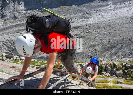 Bergsteiger steigen Leitern nach unten auf das Mer De Glace aus nahe dem Montenvers Bahnhof führt. Die Bahn wurde gebaut in viktorianischen Zeiten, Touristen auf den Gletscher zu nehmen, hat danach 150 Meter seit 1820 ausgedünnt, und zogen sich von 2300 Metern. Um den Gletscher zu gelangen müssen Sie jetzt über 100 Meter auf Leitern klettern. Stockfoto