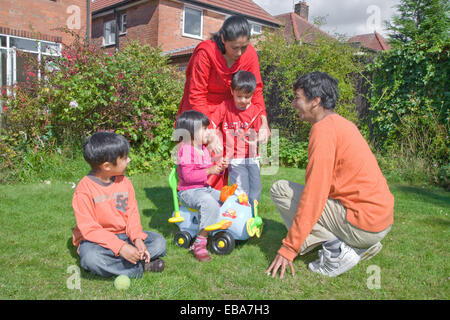 Junge Familie im Garten spielen, Stockfoto