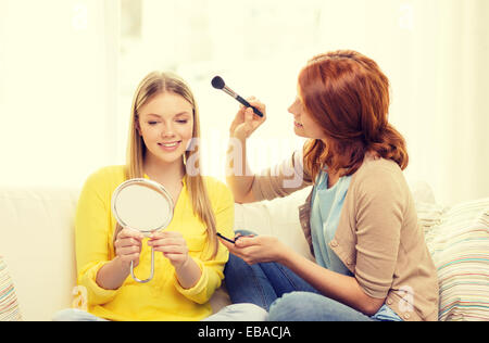 zwei lächelnde Mädchen im Teenageralter Anwendung Make-up zu Hause Stockfoto
