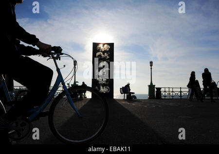 Brighton Sussex UK 28. November 2014 - Menschen aus genießen das schöne milde und sonnige Wetter auf Brighton Seafront heute durch die berühmte Statue der Wand Kiss The Kiss Wall zeigt sechs Paare küssen und entstand 1992 durch Künstler Bruce Williams Stockfoto