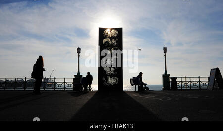 Brighton Sussex UK 28. November 2014 - Menschen aus genießen das schöne milde und sonnige Wetter auf Brighton Seafront heute durch die berühmte Statue der Wand Kiss The Kiss Wall zeigt sechs Paare küssen und entstand 1992 durch Künstler Bruce Williams Stockfoto