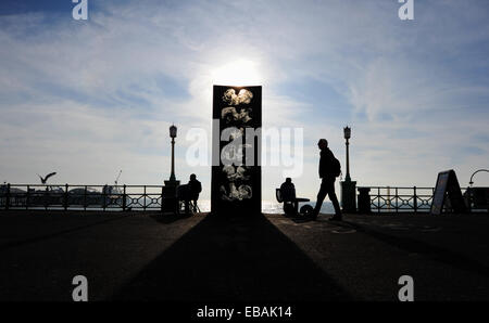 Brighton Sussex UK 28. November 2014 - Menschen aus genießen das schöne milde und sonnige Wetter auf Brighton Seafront heute durch die berühmte Statue der Wand Kiss The Kiss Wall zeigt sechs Paare küssen und entstand 1992 durch Künstler Bruce Williams Stockfoto