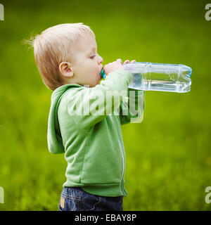 kleiner Junge trinkt Mineralwasser Stockfoto