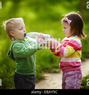 Mädchen hilft jungen Flasche zu halten Stockfoto