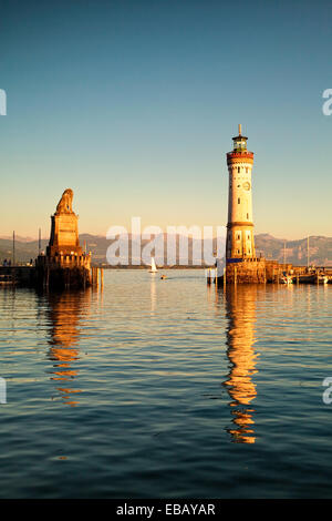 Lindauer Hafeneinfahrt mit Denkmal und dem Leuchtturm in der Abenddämmerung Stockfoto