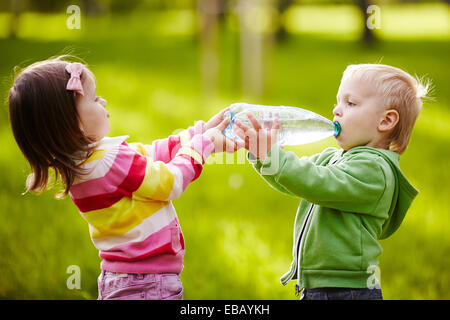 Mädchen hilft jungen Flasche zu halten Stockfoto