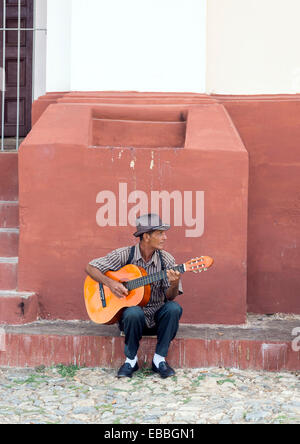 TRINIDAD, Kuba - 8. Mai 2014: Mann spielt die Gitarre vor einem der kolonialen Gebäuden. Die kubanische Musik ist eine Attraktion für Stockfoto