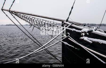 Hausboot mit Bugspriet und Bogen und Ausblick auf Amsterdam Hafen mit Schnee in Farbe Stockfoto