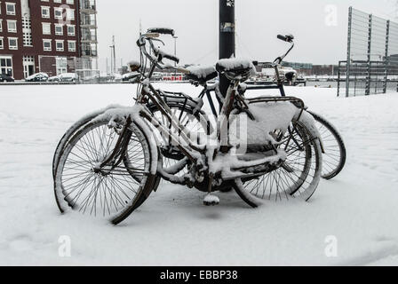 geparkte Fahrräder im Schnee gegen Laterne Pfosten Stockfoto