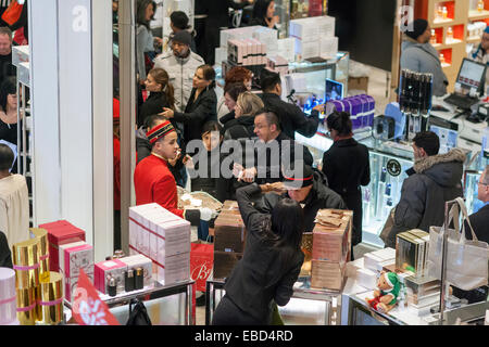 New York, USA. 28. November 2014. Käufer der Cartier Parfüm Zähler in Macy's Herald Square Flagship-Store in New York auf der Suche nach Schnäppchen am Tag nach Thanksgiving, schwarz Freitag, 28. November 2014. Viele Einzelhändler, darunter Macy, öffneten ihre Türen auf Thanksgiving Abend erweitern die shopping-Tag und geben Thanksgiving den Spitznamen 'Gray Donnerstag'. Bildnachweis: Richard Levine/Alamy Live-Nachrichten Stockfoto