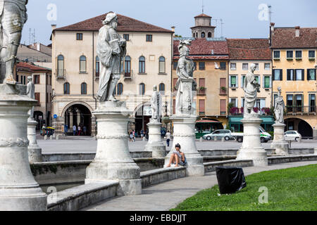 Frau liest zwischen den Statuen auf der großen Piazza Prato della Valle. Stockfoto