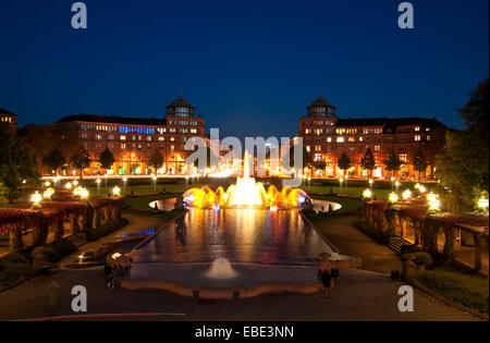 Blick auf Wasser-Brunnen in der Nacht, mit Arkadenbauten im Hintergrund bei Freidrichsplatz, Mannheim, Deutschland Stockfoto