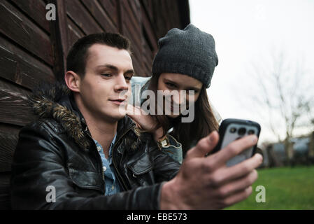 Nahaufnahme der junge Mann und junges Mädchen im freien Blick auf Handy, Deutschland Stockfoto