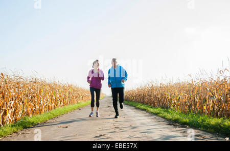 Erwachsenes paar laufen auf Landstraße, Deutschland Stockfoto