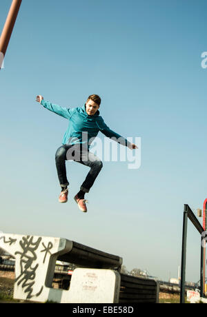 Teenager-Jungen springen über Bank im Freien, Industrail Area, Mannheim, Deutschland