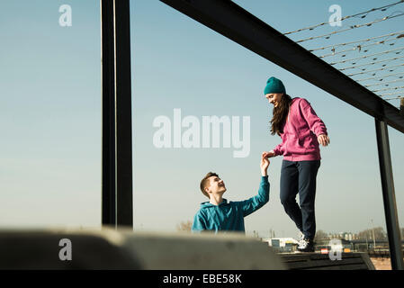 Teenager-Jungen und Mädchen hängen zusammen im Freien, Industriegebiet, Mannheim, Deutschland Stockfoto
