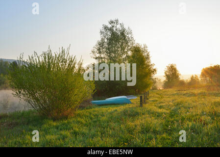 Wiese mit Booten am Strand bei Sonnenaufgang, Frühling, Mondfeld, Mainfranken, Franken, Baden-Württemberg, Deutschland Stockfoto