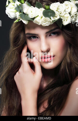 Portrait von wunderschönen Frau mit Kranz aus Blumen Stockfoto