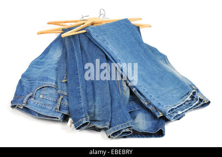 einige blaue Jeans in hölzernen Kleiderbügel auf weißem Hintergrund Stockfoto