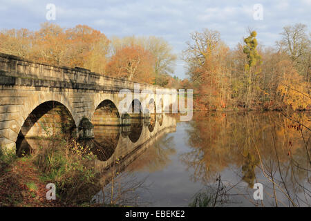 Virginia Water, Surrey, England, UK. 29. November 2014. Fünf-Bogen-Brücke spiegelt sich in den ruhigen Gewässern des Sees Virginia Wasser. Wie die Sonne durch die Wolken, die Verbesserung der Blätter im Herbst brach, stiegen die Temperaturen auf einem warmen 15 Grad Celsius in Surrey heute. Bildnachweis: Julia Gavin UK/Alamy Live-Nachrichten Stockfoto