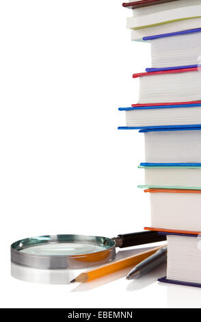 Haufen neuer Bücher, Stift und Lupe isoliert auf weißem Hintergrund Stockfoto