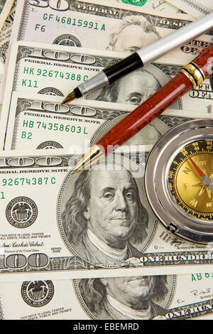 Tintenschreiber und goldene Kompass auf US-Dollar Stockfoto